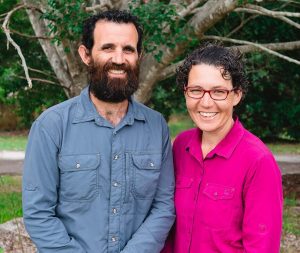 Image of Adam and Carmel, standing in front of a tree.