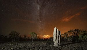 Photo of a termite mound against a starry sunset in Marrakai, Northern Territory, Australia.